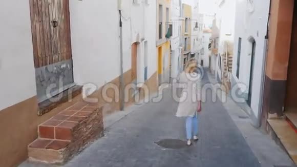 年轻的女游客沿着欧洲古老的中世纪小镇的狭窄街道散步他环顾四周欣赏视频的预览图