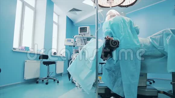 在医院手术室对病人进行侵入性手术的专业外科医生团队外科医生的使用和视频的预览图