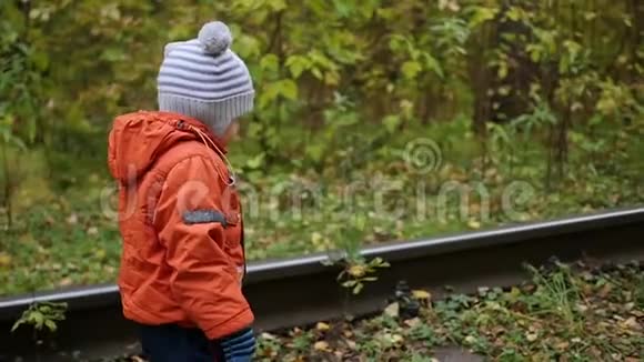 一个孤独的男孩走在铁轨上危险的游戏和娱乐活动秋日视频的预览图