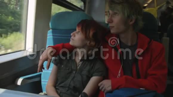 年轻漂亮快乐的时髦夫妇坐在火车旁谈论着他们的生活笑着开玩笑暑假假期视频的预览图
