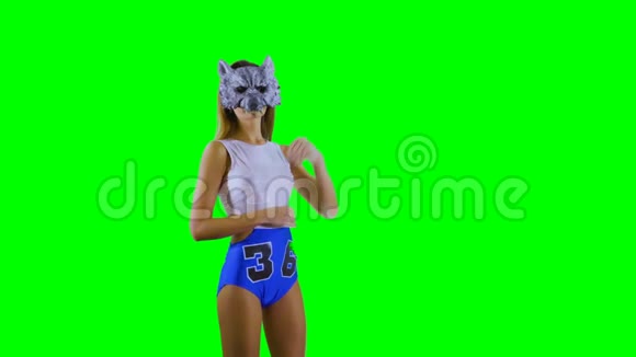 戴着狼面具的女孩在绿色背景下展示了一些东西视频的预览图