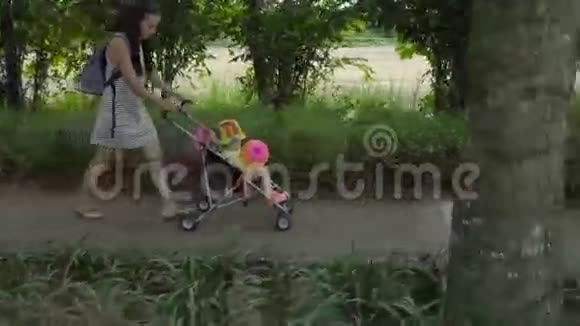 带着非洲辫子的漂亮女人带着婴儿车里的小女孩视频的预览图