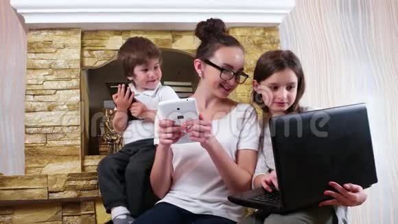 女孩在笔记本电脑上展示姐姐和弟弟的照片家庭成员在家社交视频的预览图