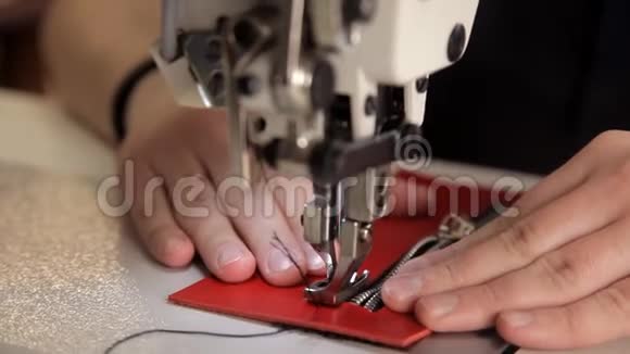 在车间里一个人用缝纫机缝制真皮皮革制品制造程序视频的预览图