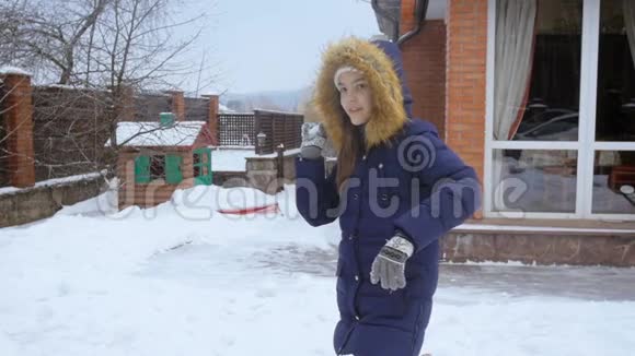 欢快的少女在自家后院投掷雪球的慢镜头视频的预览图