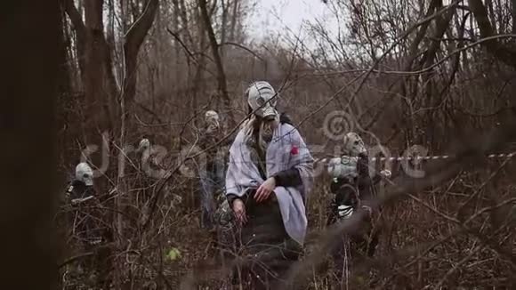 森林里几个戴着防毒面具的人环顾四周找点东西视频的预览图