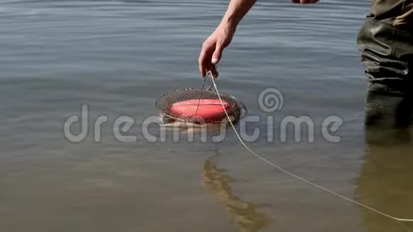 夏天钓鱼时在河水上的笼子里抓鱼视频的预览图