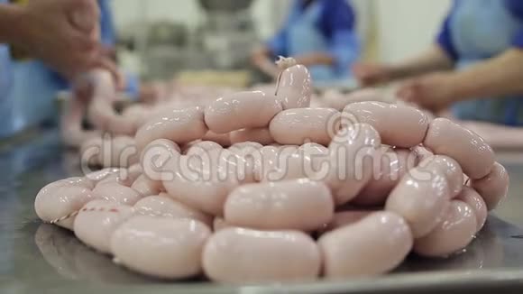 食品厂工人在自动化食品生产设备上生产香肠特写视频的预览图