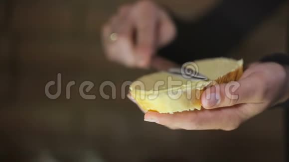 女人的手在面包上撒黄油慢动作视频的预览图