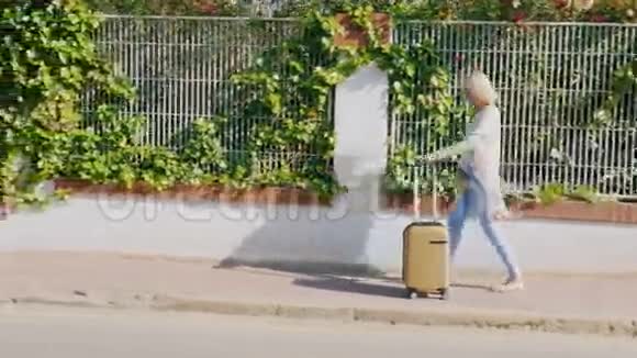 游客带着平板电脑和旅行袋走在街上的度假小镇上视频的预览图