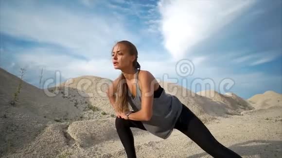 在城外的砾石山上做运动的女人视频的预览图