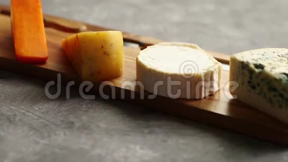 用叉子和刀子在木板上供应各种奶酪视频的预览图