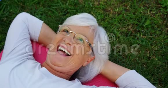 4k花园里躺在运动垫上的老妇人视频的预览图