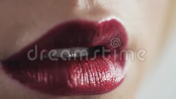 特写镜头女人脸和化妆刷在嘴唇上涂上红色口红金发年轻的白种人模特视频的预览图