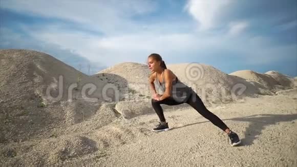 在城外的砾石山上做运动的女人视频的预览图