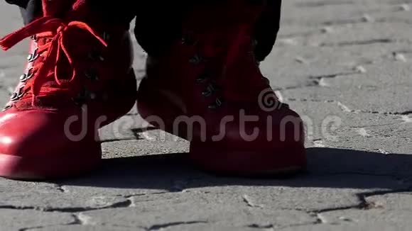在斯洛莫红色的靴子在铺着瓷砖的人行道上跳舞视频的预览图