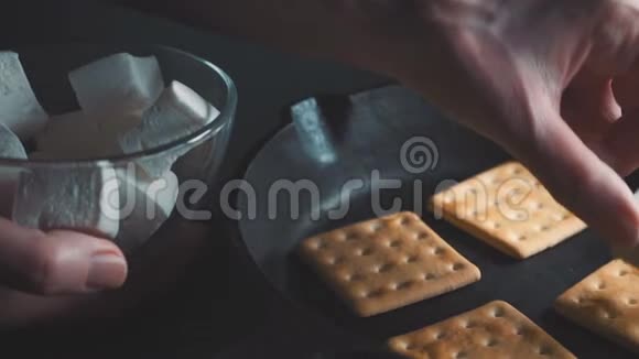 从碗里拿出一只棉花糖放在热饼干上视频的预览图