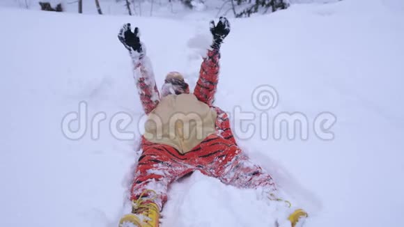 漂亮的年轻女人穿着滑稽的老虎套装冬天躺在雪地里下雪时吐雪慢慢慢慢视频的预览图