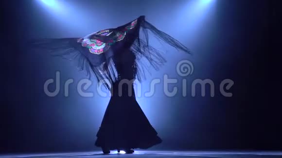 弗拉门戈女孩在西班牙燃烧舞的手中拿着一个咒语跳舞从后面发光烟雾背景视频的预览图