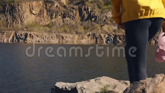 穿黄色夹克的女游客享受大自然的休息视频的预览图