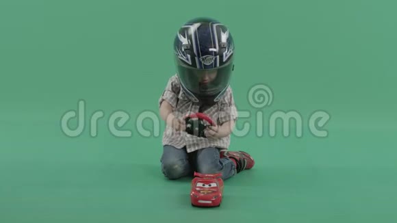戴着头盔玩方向盘的小男孩视频的预览图