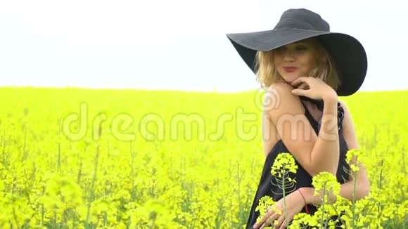一个女孩在油菜花田中间带着甜美的微笑视频的预览图