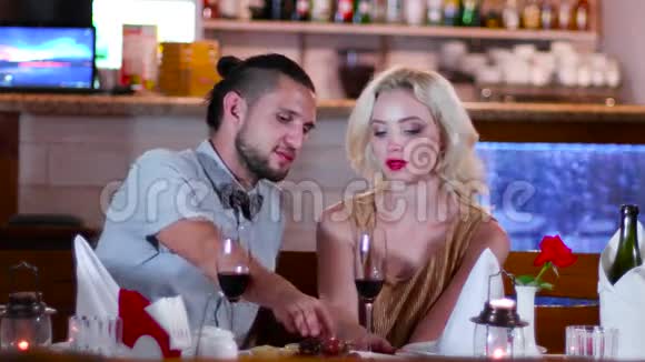 浪漫的气氛在餐厅年轻的情侣男女在咖啡馆的浪漫约会迷人的眼睛美丽视频的预览图