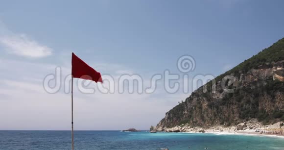 海滩上的红色警示旗蓝色的大海天空和陆地背景下的一个风与海夏日视频视频的预览图