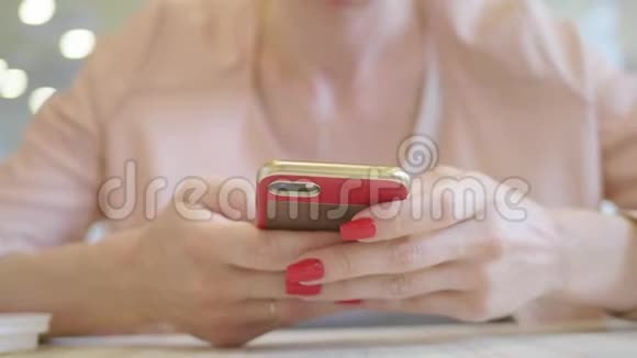 年轻女性在工作休息时坐在舒适的咖啡店里用手机迷人的快乐女性阅读视频的预览图