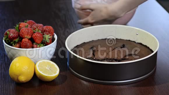 厨房里的女孩用摩丝做巧克力蛋糕倒入草莓慕斯视频的预览图