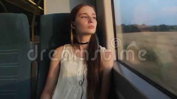 年轻的黑发美女长时间思考她的生活坐在火车的窗户边视频的预览图