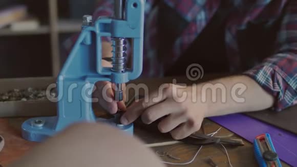 皮革制造商将金属按钮插入皮带工匠工视频的预览图