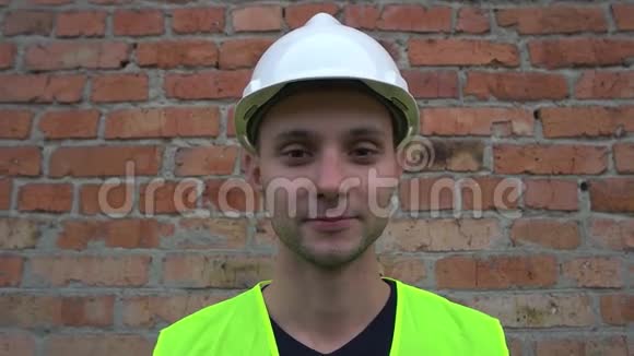在砖墙附近戴头盔的建筑工人视频的预览图