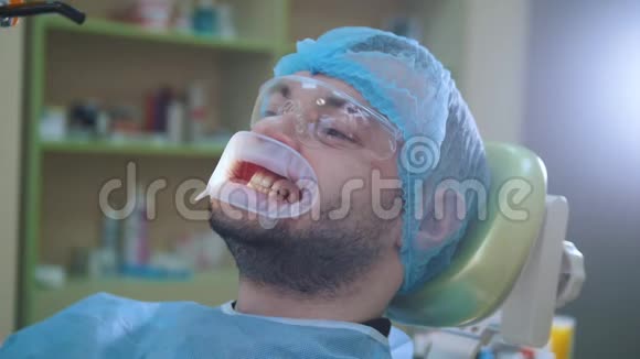 牙科办公室有拉钩的医生和病人紫外线和橙色保护屏视频的预览图