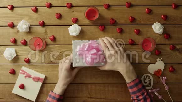 年轻人得到手工纸情人节礼物作为情人节礼物俯视视频的预览图