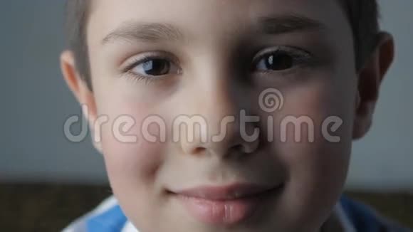 特写小男孩看镜头的肖像他很快乐微笑着视频的预览图