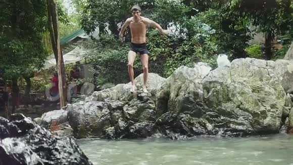 年轻人在瀑布中缓慢地跳跃1920x1080视频的预览图