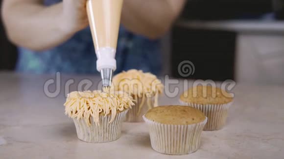 用橙色奶油装饰纸杯蛋糕用烹饪袋糖果做松饼视频的预览图