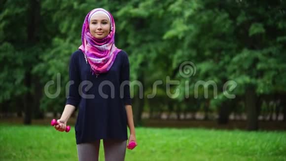 穆斯林女孩在户外用哑铃锻炼视频的预览图