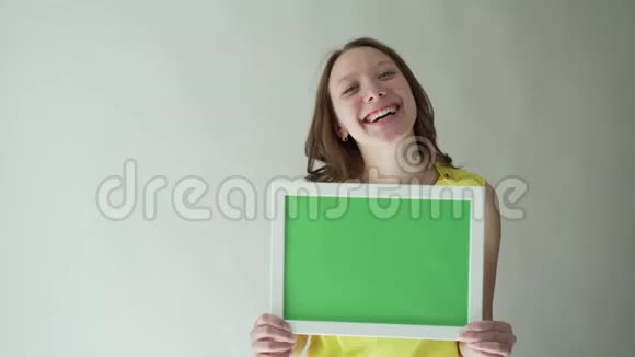有魅力的女人手里拿着一个彩色的标志在灰色的背景上视频的预览图
