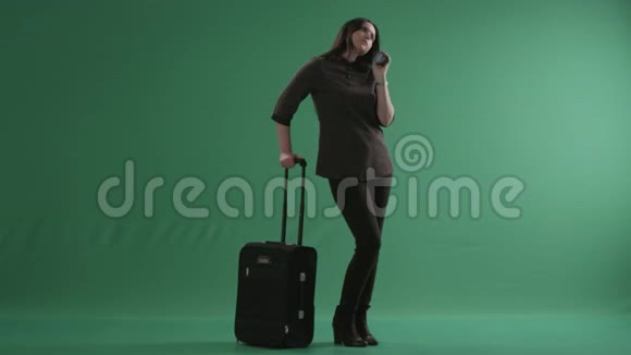 一个带着手提箱在电话里说话的年轻疲惫的女人视频的预览图