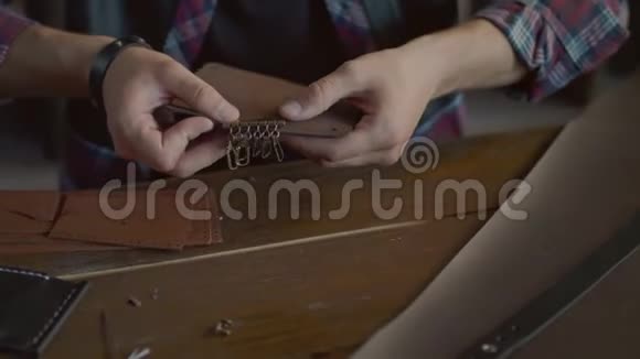 工匠在家庭车间制作皮革钥匙链皮革车间视频的预览图
