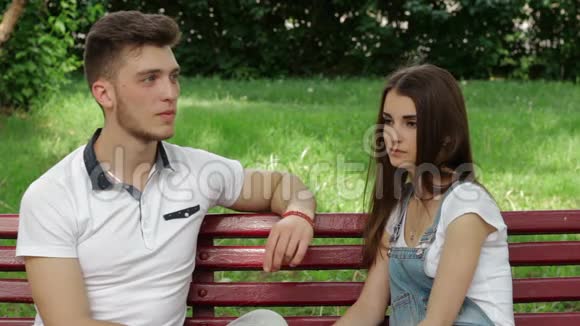 一个男人和一个女孩坐在长凳上说话视频的预览图