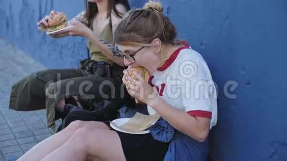 两个朋友在街上吃芝士汉堡视频的预览图