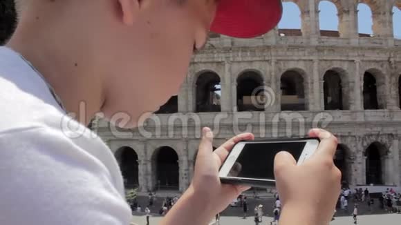 白人男孩用手机在欧洲古城美丽的景色上发短信视频的预览图