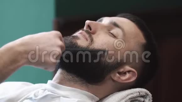 男理发师在理发店梳胡子视频的预览图