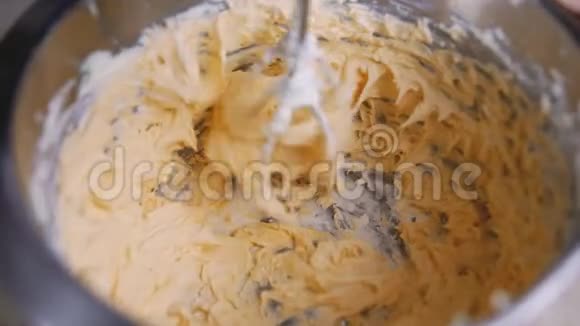 橙色奶油在搅拌机里搅拌家庭主妇混合奶油做松饼近景视频的预览图