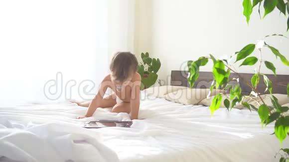 小儿子躺在卧室的床上看着上网板视频的预览图