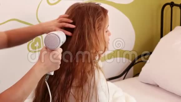 一个年轻的女孩她的头发被母亲擦干视频的预览图