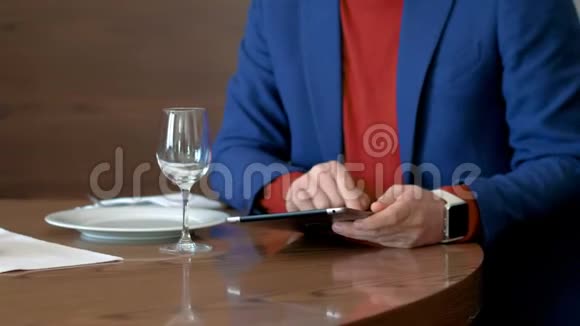 一位在餐馆吃午饭时使用平板电脑工作的商人视频的预览图